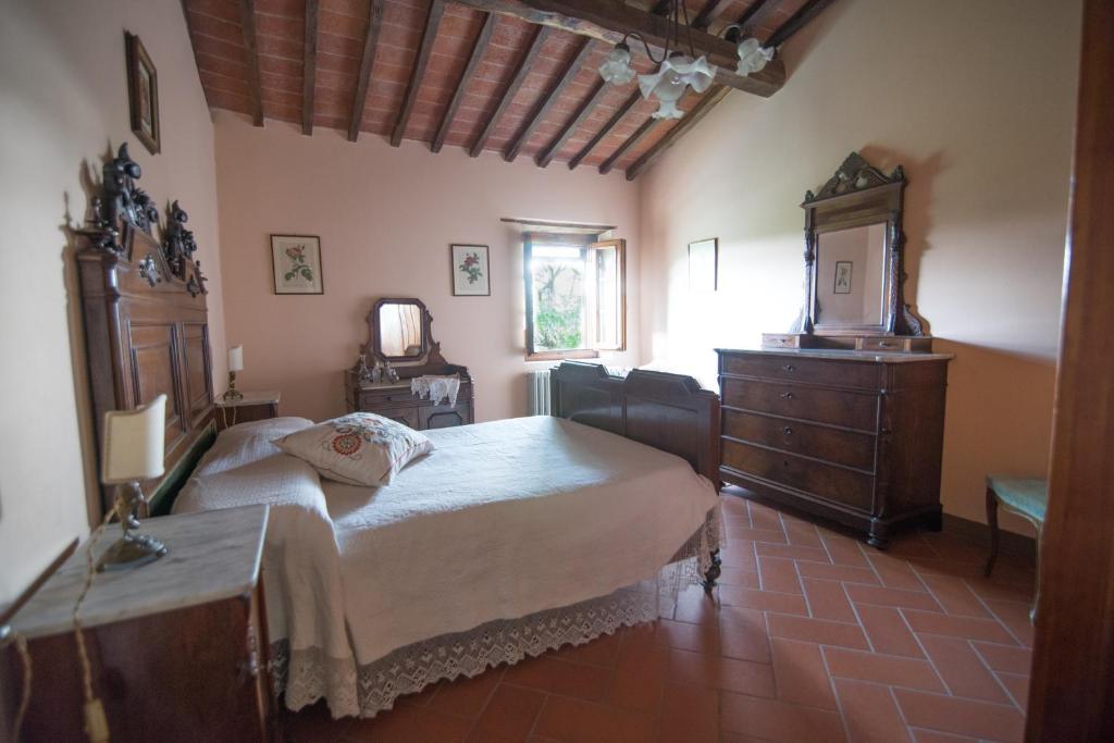 une chambre avec un lit, une commode et un miroir dans l'établissement Heated pool - Arte e Terme immerse nella natura, à Massa e Cozzile