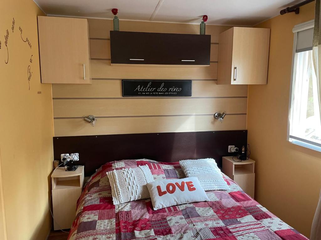 - une chambre avec un lit muni d'un signe d'amour dans l'établissement Coquet mobilehome 8 places, à Puget-sur Argens