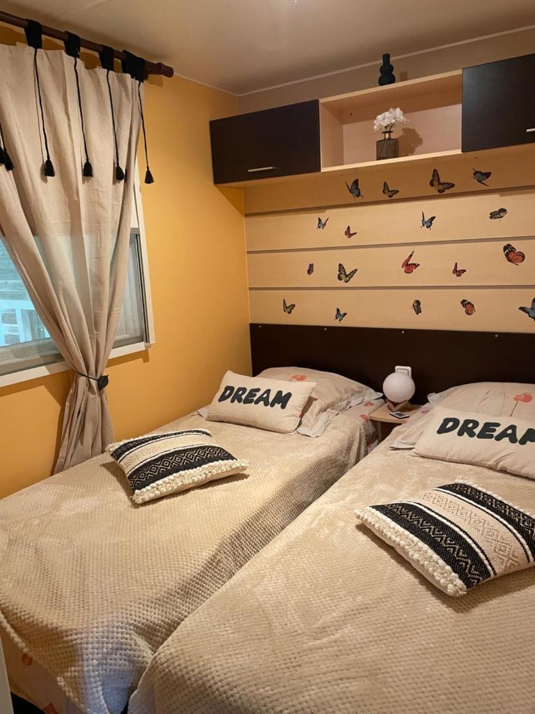 deux lits côte à côte dans une chambre dans l'établissement Coquet mobilehome 8 places, à Puget-sur Argens