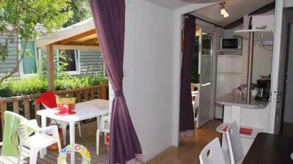 un balcon avec une table et des chaises et une cuisine dans l'établissement Camping 4 étoiles - Parc aquatique - eebadc, à Bormes-les-Mimosas