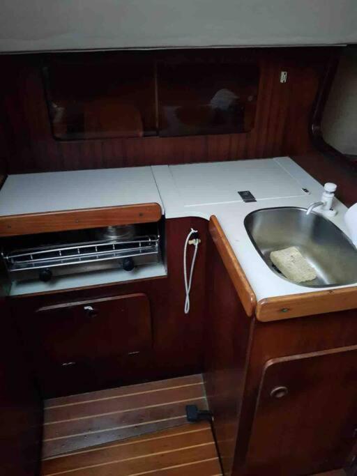 une petite cuisine avec un évier et un évier dans l'établissement Bateau Jeanneau fantasia 8m à louer, à La Rochelle
