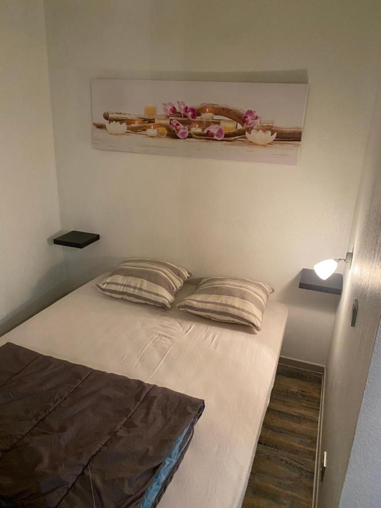 - un lit dans un dortoir orné de fleurs sur le mur dans l'établissement Résidence Bellevue Cauterets, à Cauterets