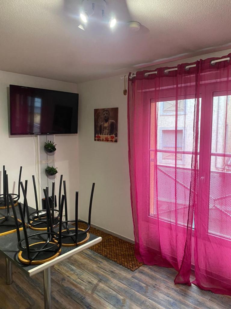 Cette chambre dispose de rideaux roses et d'une fenêtre. dans l'établissement Résidence Bellevue Cauterets, à Cauterets