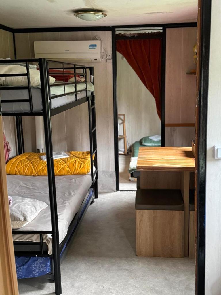 une chambre avec deux lits superposés et un bureau dans l'établissement Gîte pèlerin - "Les Sources" - Chambres Dortoirs, au Vigan
