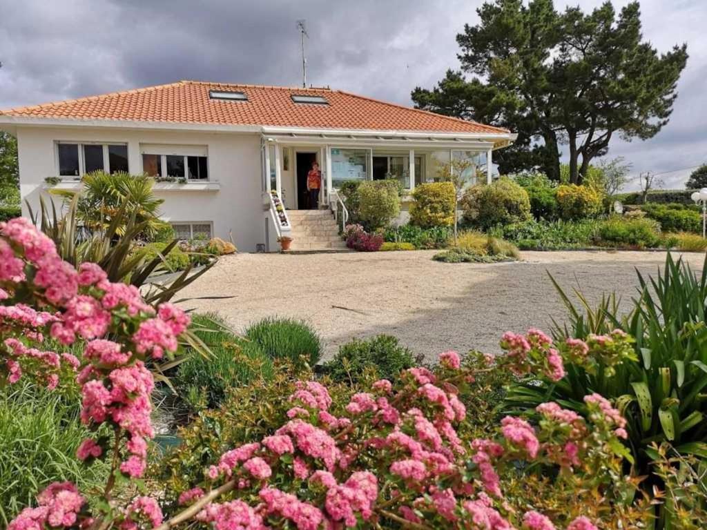 une maison avec des fleurs roses devant elle dans l'établissement Camping 4 étoiles - Parc aquatique - efcia0, à Soullans