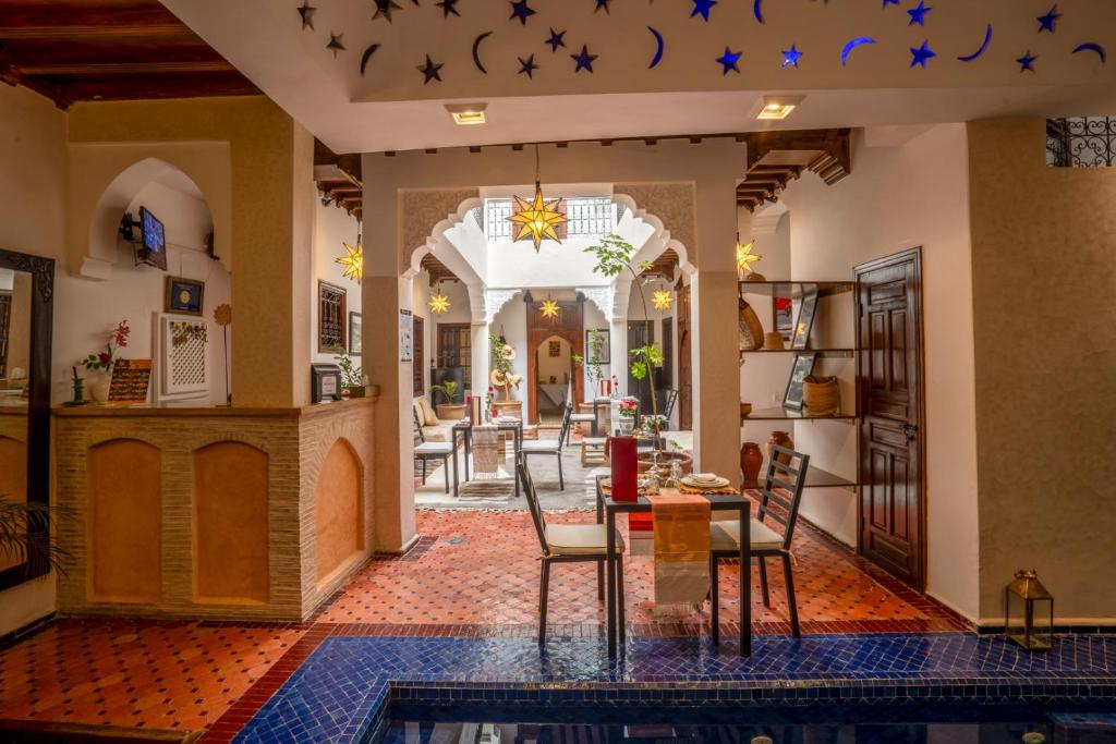 une salle à manger et un salon avec une table et des chaises dans l'établissement Riad Sun of Kech, à Marrakech