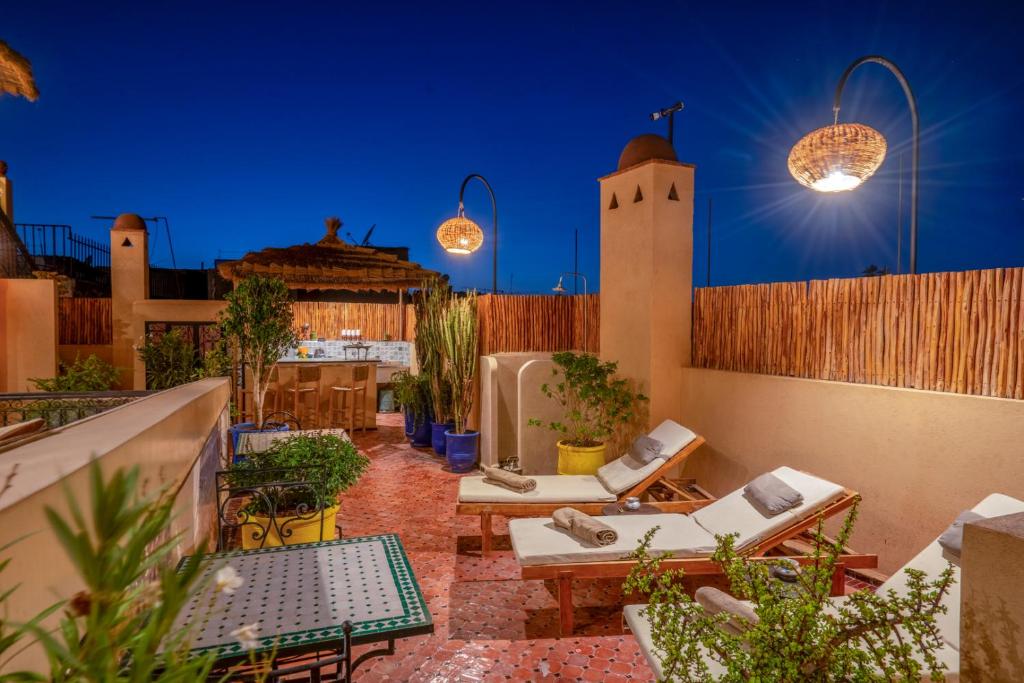 d'un toit-terrasse avec des chaises, des tables et des lumières. dans l'établissement Riad Sun of Kech, à Marrakech 22 autres photos