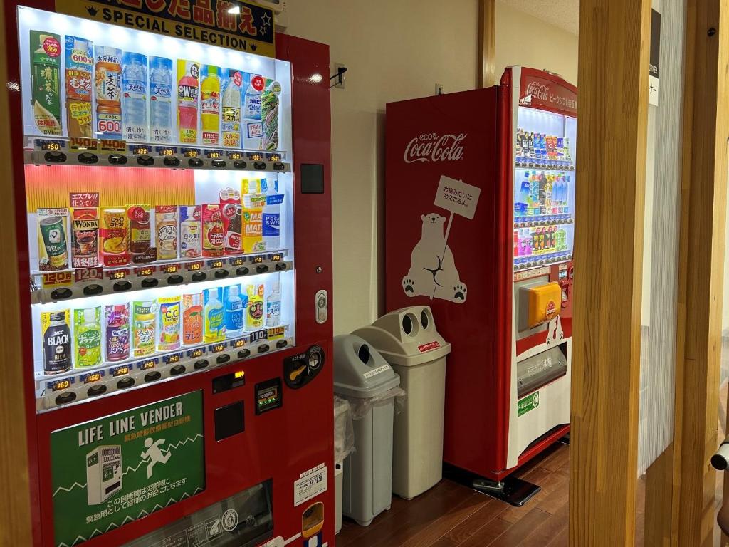 - un distributeur automatique de cocacola dans un magasin à côté d'un réfrigérateur dans l'établissement Misato Town Community Lodge Wakuasu, à Daisen