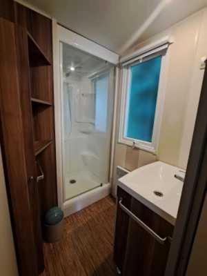 une salle de bain avec un lavabo blanc et une douche dans l'établissement Camping 3 étoiles - Piscine - eeebbh, à Saint-Céré