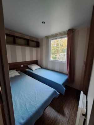 deux lits dans une petite pièce avec une fenêtre dans l'établissement Camping 3 étoiles - Piscine - eeebbh, à Saint-Céré