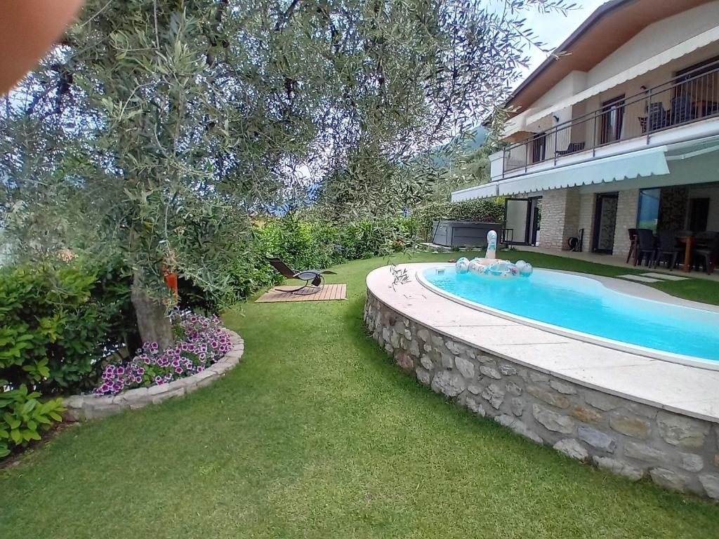une piscine dans une cour à côté d'une maison dans l'établissement Villa Mimosa-Con piscina e vista lago, à Brenzone