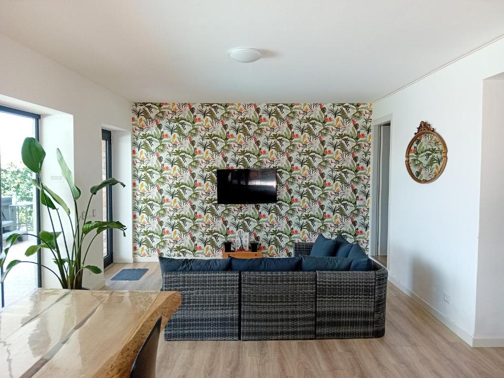 un salon avec un canapé et une télévision sur un mur dans l'établissement Villa Mimosa-Con piscina e vista lago, à Brenzone