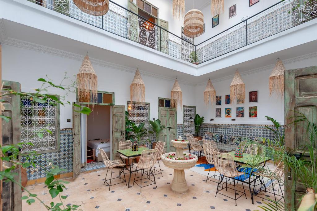 un restaurant avec des tables et des chaises dans une salle ornée de plantes dans l'établissement Riad Bab Taghzout Marrakech, à Marrakech