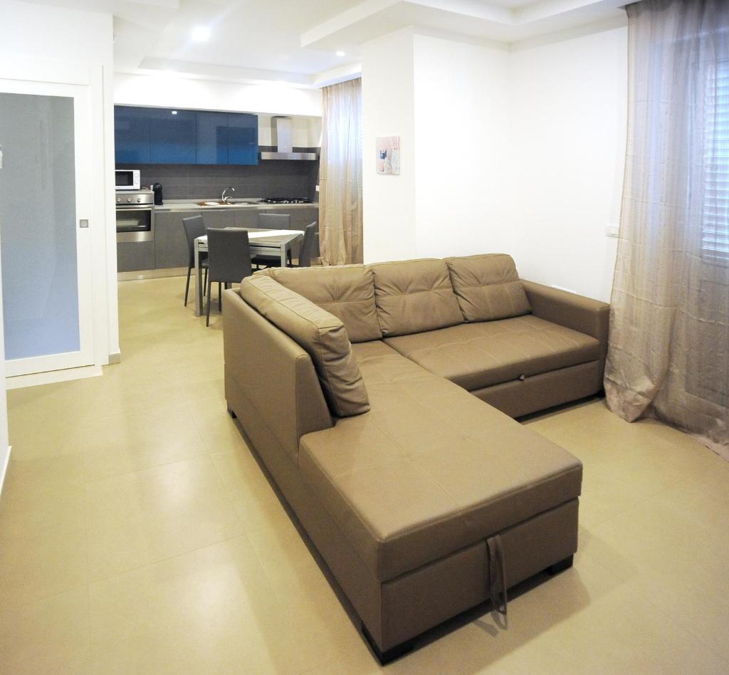 un salon avec un canapé marron et une cuisine dans l'établissement THE FLOWERs, à Pontecagnano