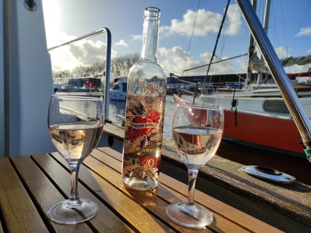 une bouteille de vin et deux verres sur une table dans l'établissement bateau au port, à Ouistreham