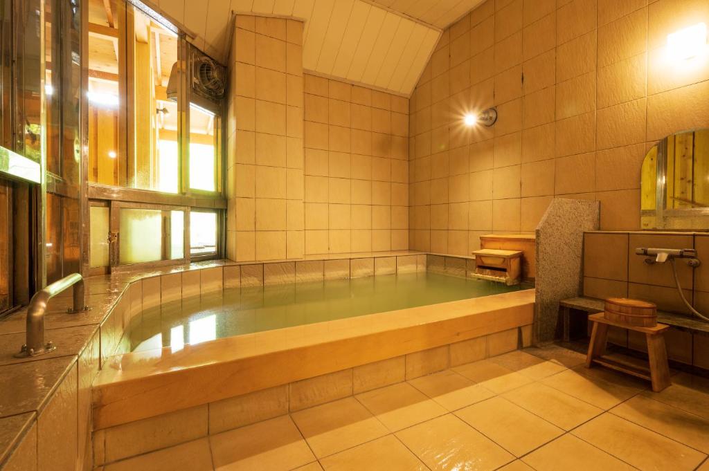 une grande salle de bains avec une grande baignoire. dans l'établissement 奥日光湯元温泉ゆの森, à Nikkō