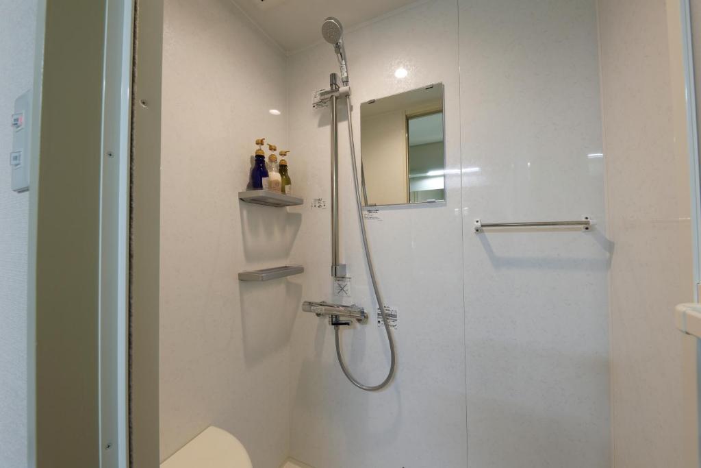 une salle de bain avec une douche avec une porte vitrée dans l'établissement Bekkan Yosanoso, à Miyazu