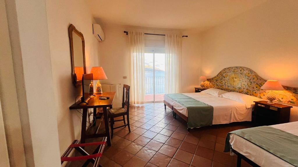 une chambre avec un lit, une table et un miroir dans l'établissement Bay Palace Mazzarò, à Taormine 82 autres photos