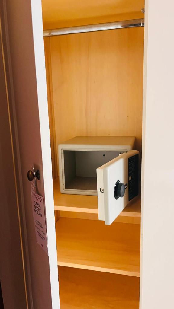 un four micro-ondes sur une étagère dans un placard dans l'établissement Bay Palace Mazzarò, à Taormine