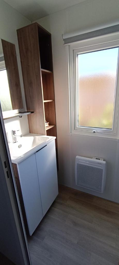 une petite cuisine avec un évier et une fenêtre dans l'établissement Mobil home chez Véronique, à Canet