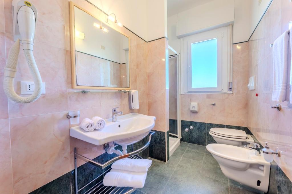 une salle de bain avec un lavabo et des toilettes dans l'établissement Paglianza Hotel, à Peschici