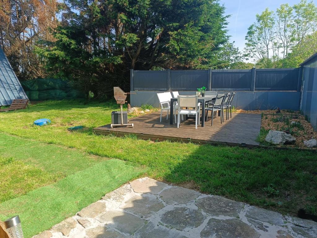un patio avec une table et des chaises dans une cour dans l'établissement La cabane du phare du minou, à Plouzané