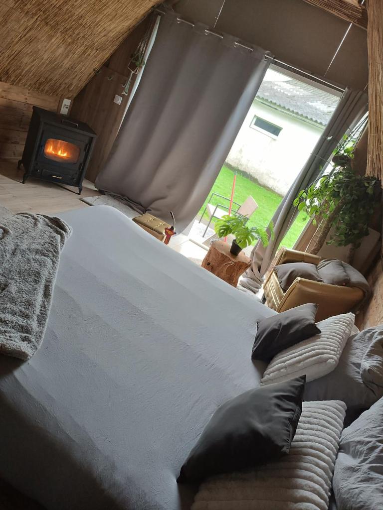 un grand lit dans une chambre avec une grande fenêtre dans l'établissement La cabane du phare du minou, à Plouzané