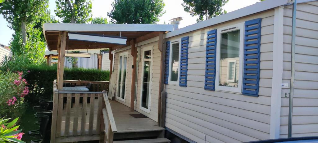 une petite maison avec une véranda et un auvent dans l'établissement Mobile home 6 personnes Valras plage, à Valras-Plage