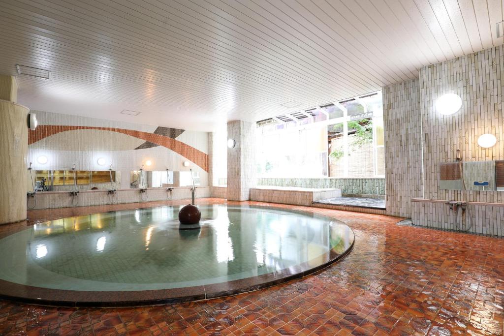 Cette grande chambre dispose d'une piscine au milieu de la pièce. dans l'établissement 赤湯温泉 丹泉ホテル, à Nanyo