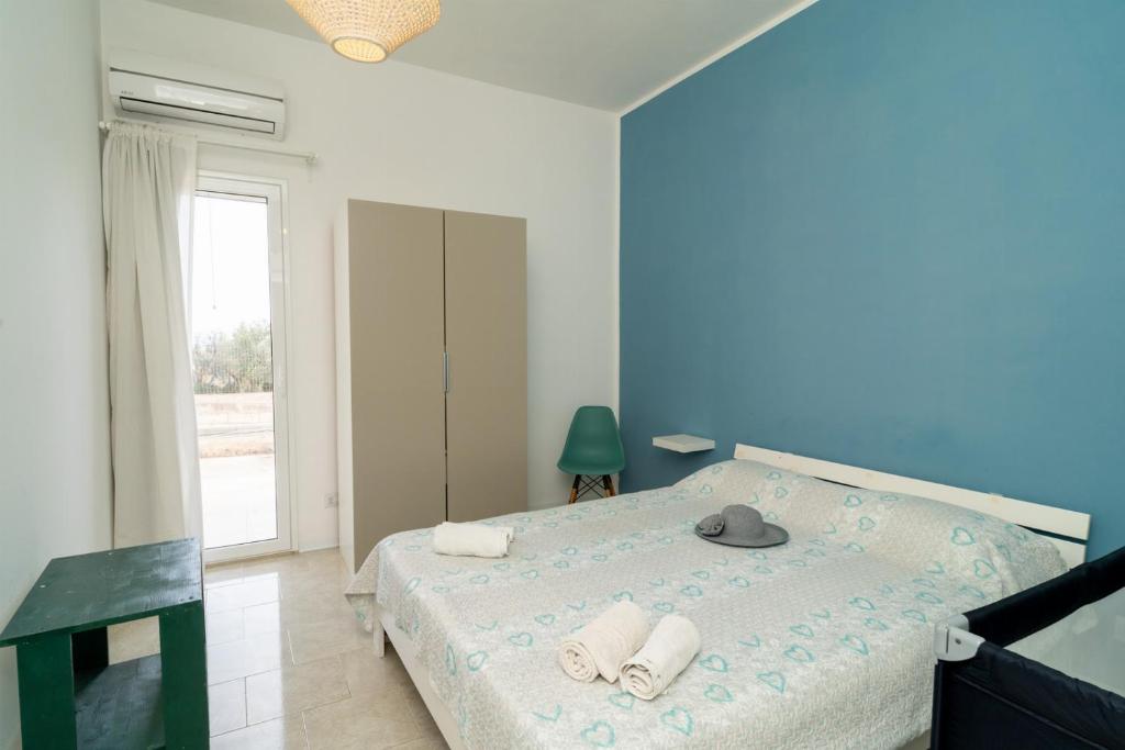 - une chambre avec un lit, des serviettes et une fenêtre dans l'établissement Villa Malamuri, à Villaggio Azzurro