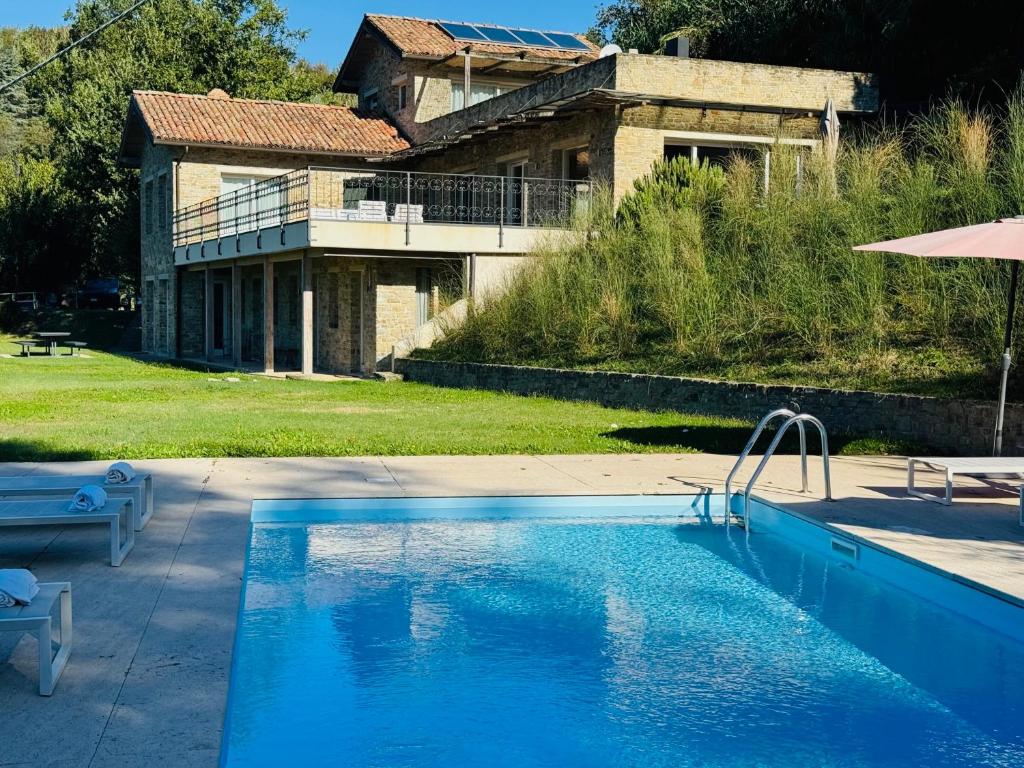 une grande piscine devant une maison dans l'établissement Villa La Ginestra Piemonte with private pool, à Bistagno
