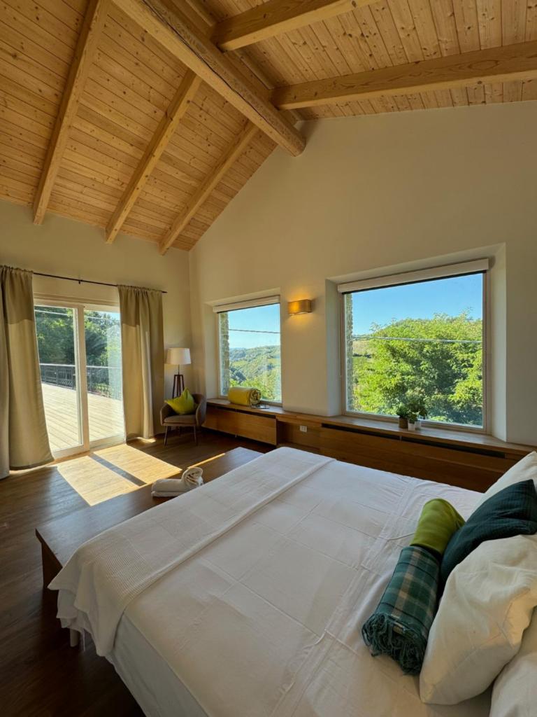 une chambre avec un grand lit et deux fenêtres dans l'établissement Villa La Ginestra Piemonte with private pool, à Bistagno 83 autres photos