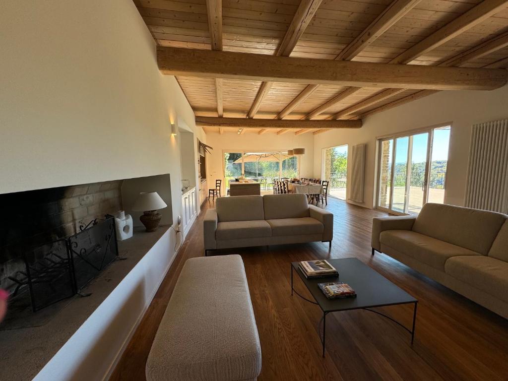 un salon avec deux canapés et une cheminée dans l'établissement Villa La Ginestra Piemonte with private pool, à Bistagno