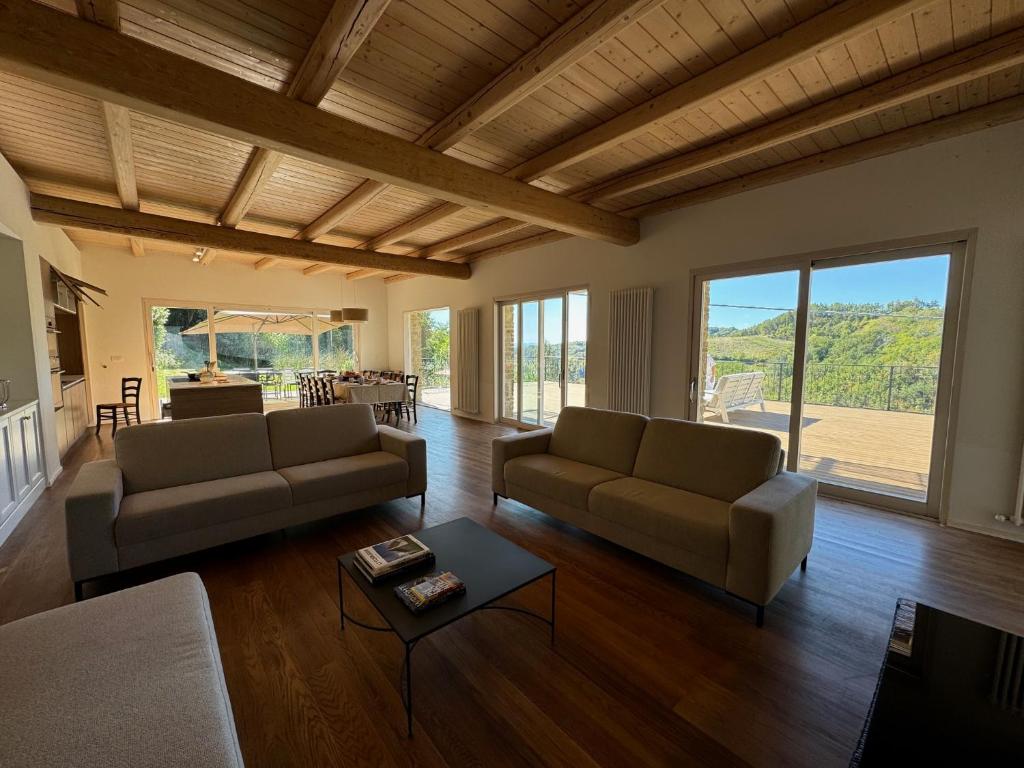 un salon avec deux canapés et une table dans l'établissement Villa La Ginestra Piemonte with private pool, à Bistagno