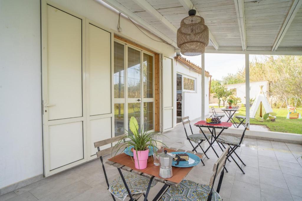 un patio avec une table et des chaises sur un porche dans l'établissement Villa Malamuri, à Villaggio Azzurro