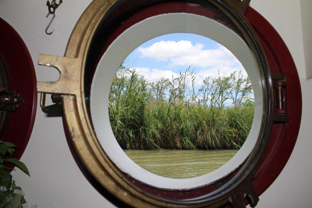 - une fenêtre ronde avec vue sur une étendue d'eau dans l'établissement Péniche Mirage-chambre d'hôtes, à Carcassonne