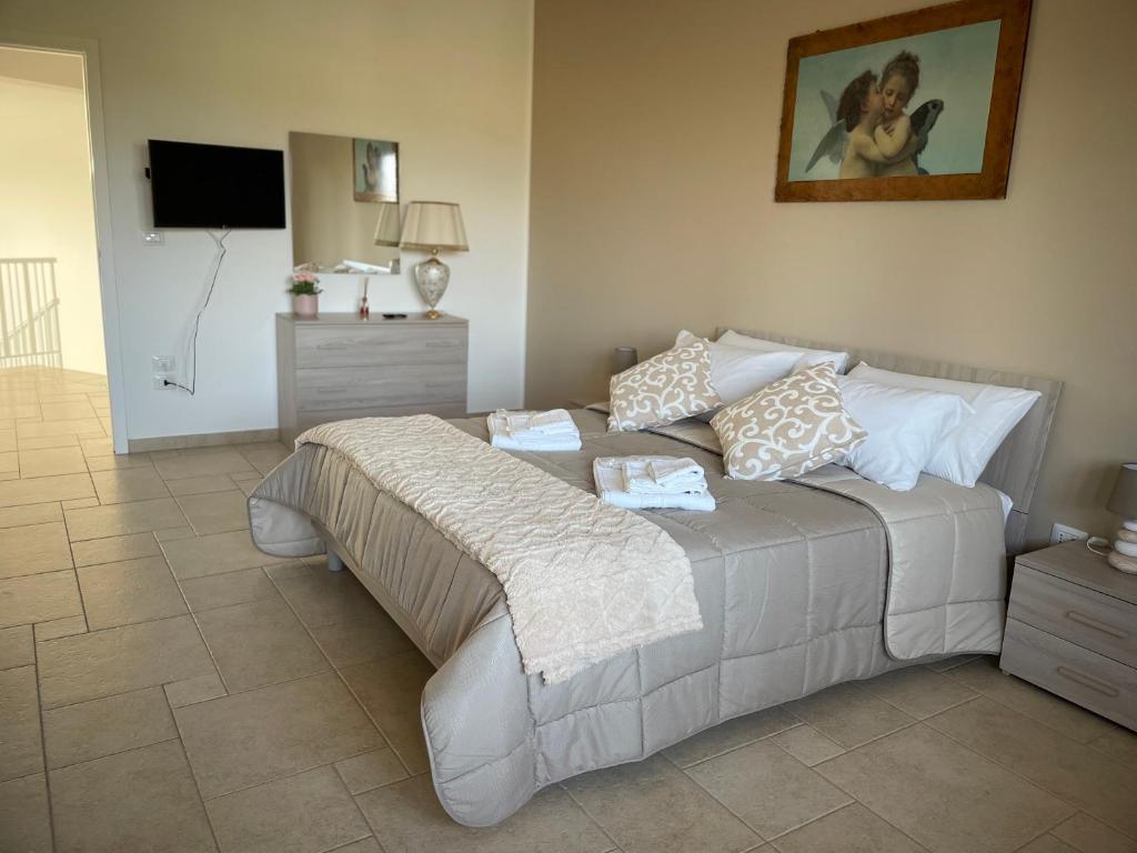 une chambre avec un grand lit avec des oreillers dessus dans l'établissement Antica Foggia Vetere villa con piscina, à Ceglie Messapica