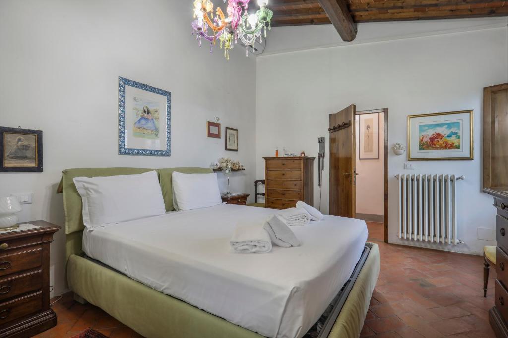 une chambre avec un grand lit et un lustre dans l'établissement Villa Laura, à Il Balzo 43 autres photos