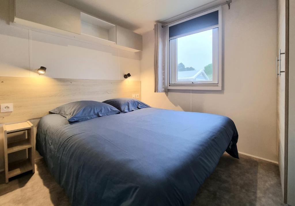 une chambre avec un grand lit et une fenêtre dans l'établissement Mobil home tout confort dans parc résidentiel de loisirs, à Saint-Hilaire-de-Riez 34 autres photos