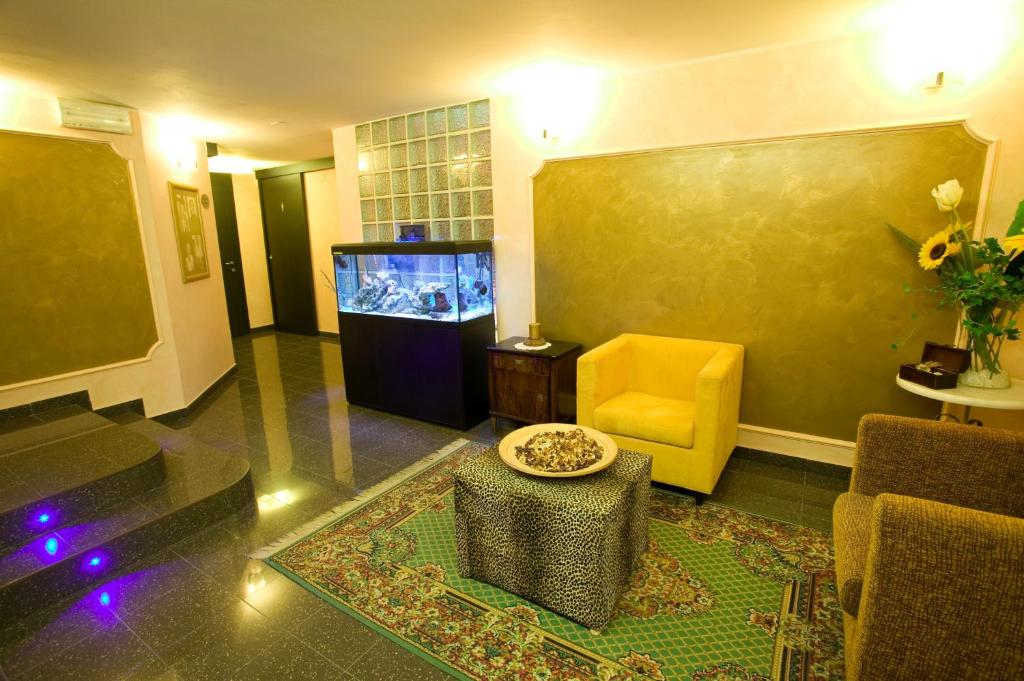 - un salon avec un aquarium et une chaise jaune dans l'établissement Hotel Strand, à Bellaria-Igea Marina