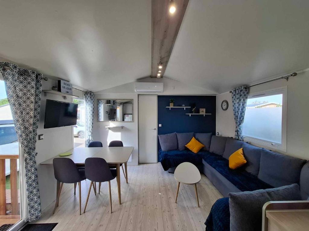 un salon avec un canapé bleu et une table dans l'établissement Bungalow Cinéric, à Canet