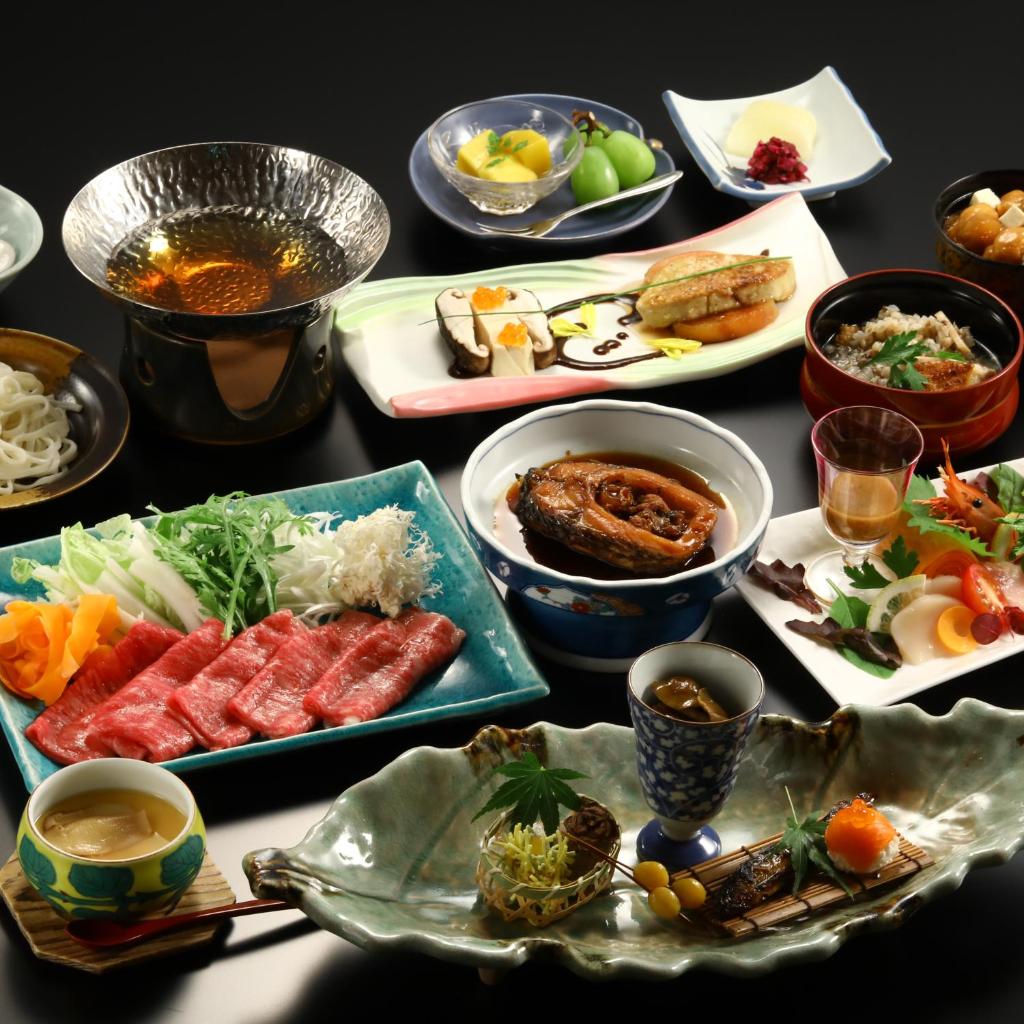 une table avec de nombreuses assiettes de nourriture dessus dans l'établissement Ogiwarakan, à Chikuma