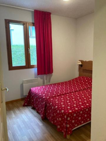 - une chambre avec un lit rouge et une fenêtre dans l'établissement Chez Pilou, à Arvieux