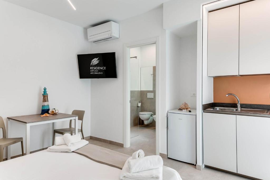 Cette chambre blanche dispose d'une cuisine et d'un évier. dans l'établissement Residence Diffuso Arcobaleno, à Gabicce Mare