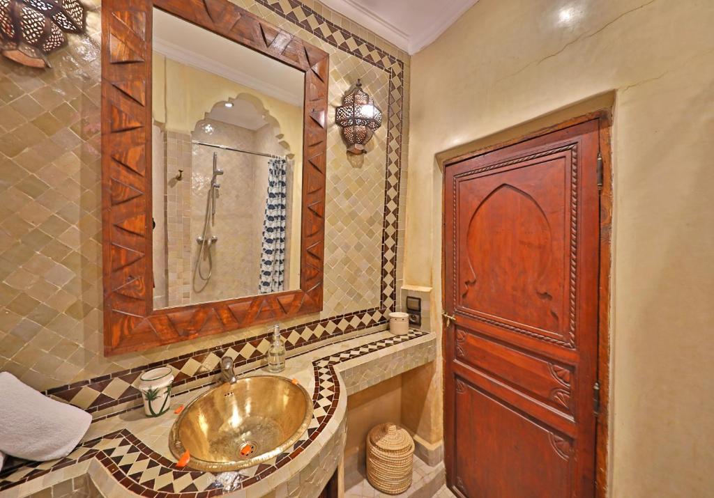 une salle de bain avec un lavabo et un grand miroir dans l'établissement Riad Zayane, à Marrakech 27 autres photos