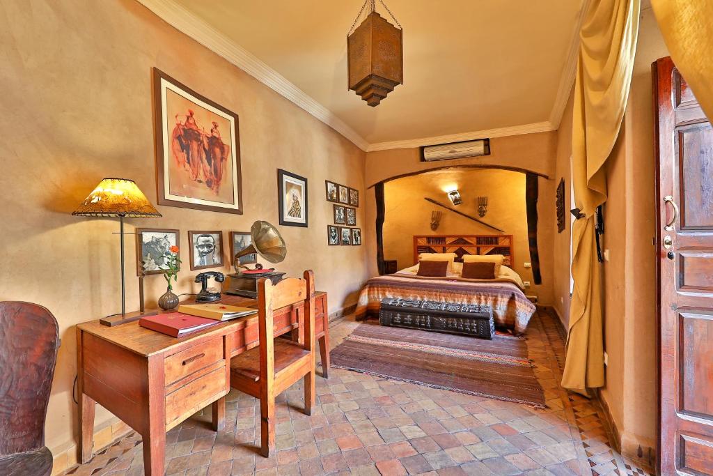 une chambre avec un lit et un bureau dans une pièce dans l'établissement Riad Zayane, à Marrakech