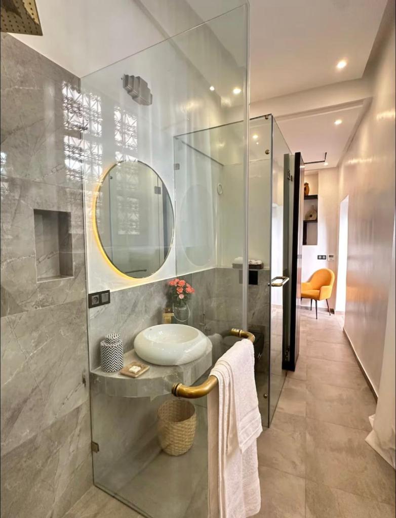 une salle de bain avec un lavabo et une douche en verre dans l'établissement Riad Manzal, à Marrakech