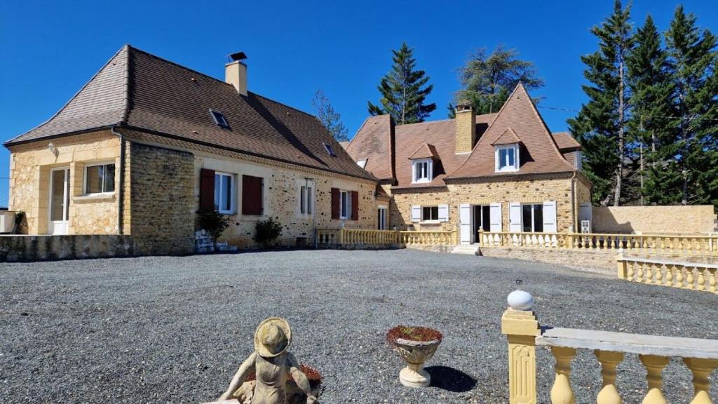 une grande maison avec une cour en face dans l'établissement Gites Domaine de Sweendy, au Bugue