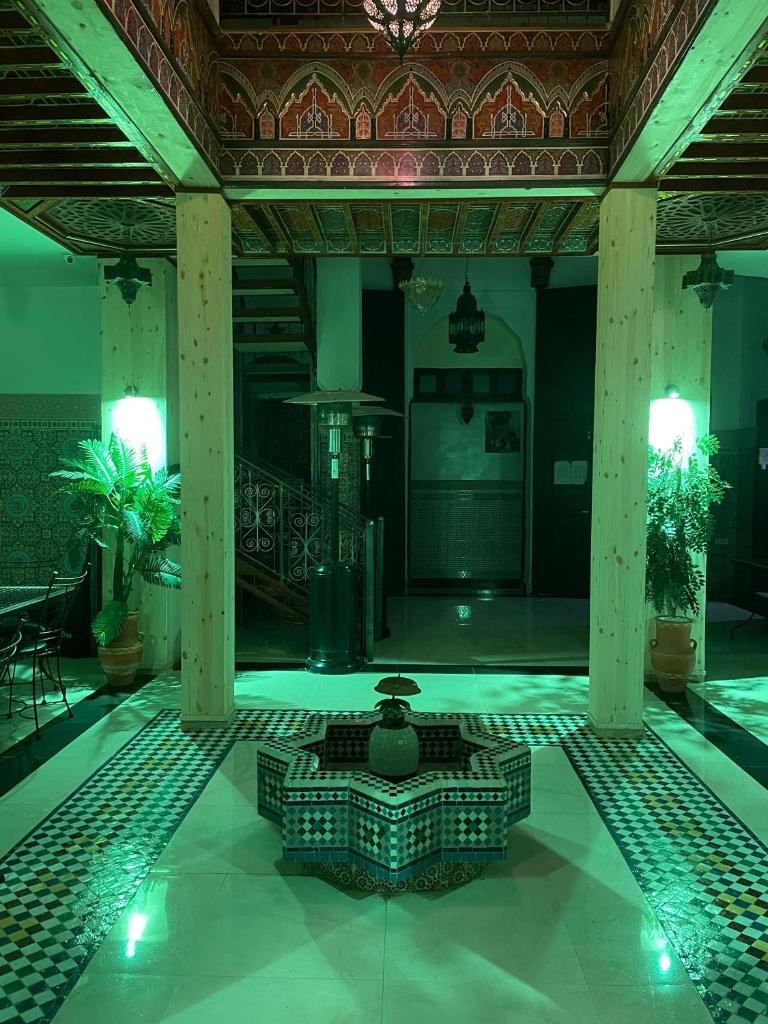 - une piscine avec une fontaine au milieu d'un bâtiment dans l'établissement La Casa Espanyola, à Fès