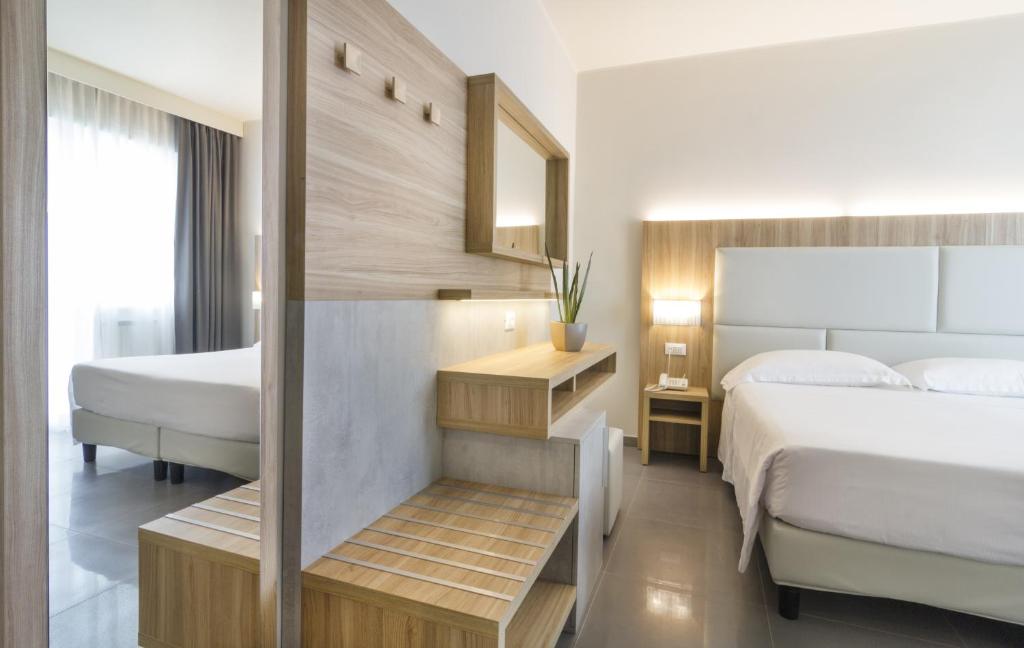 une chambre d'hôtel avec deux lits et un miroir dans l'établissement Hotel Meridiano, à Termoli 35 autres photos